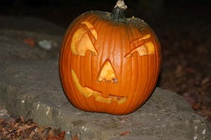 A carved pumpkin on a rock